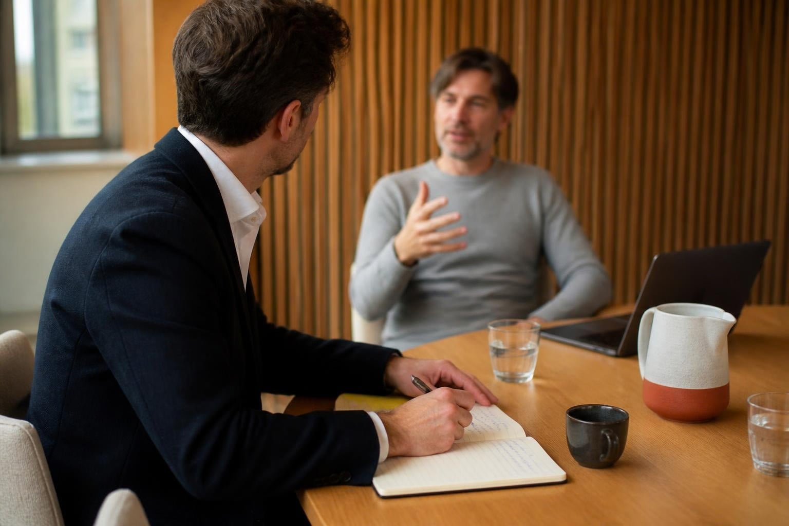 An adviser takes notes while a client explains their situation