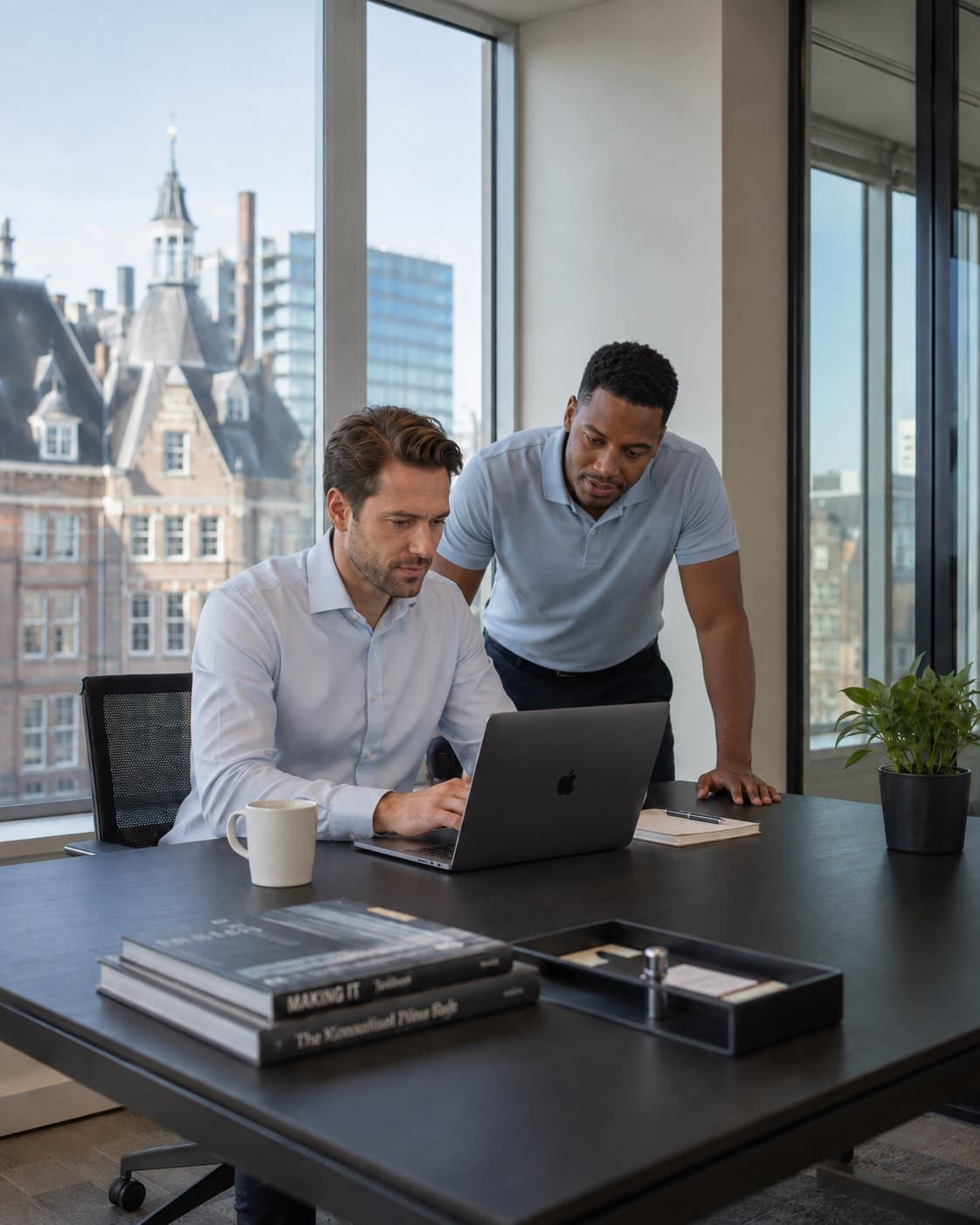 Twee professionals beoordelen samen een dossier achter de laptop